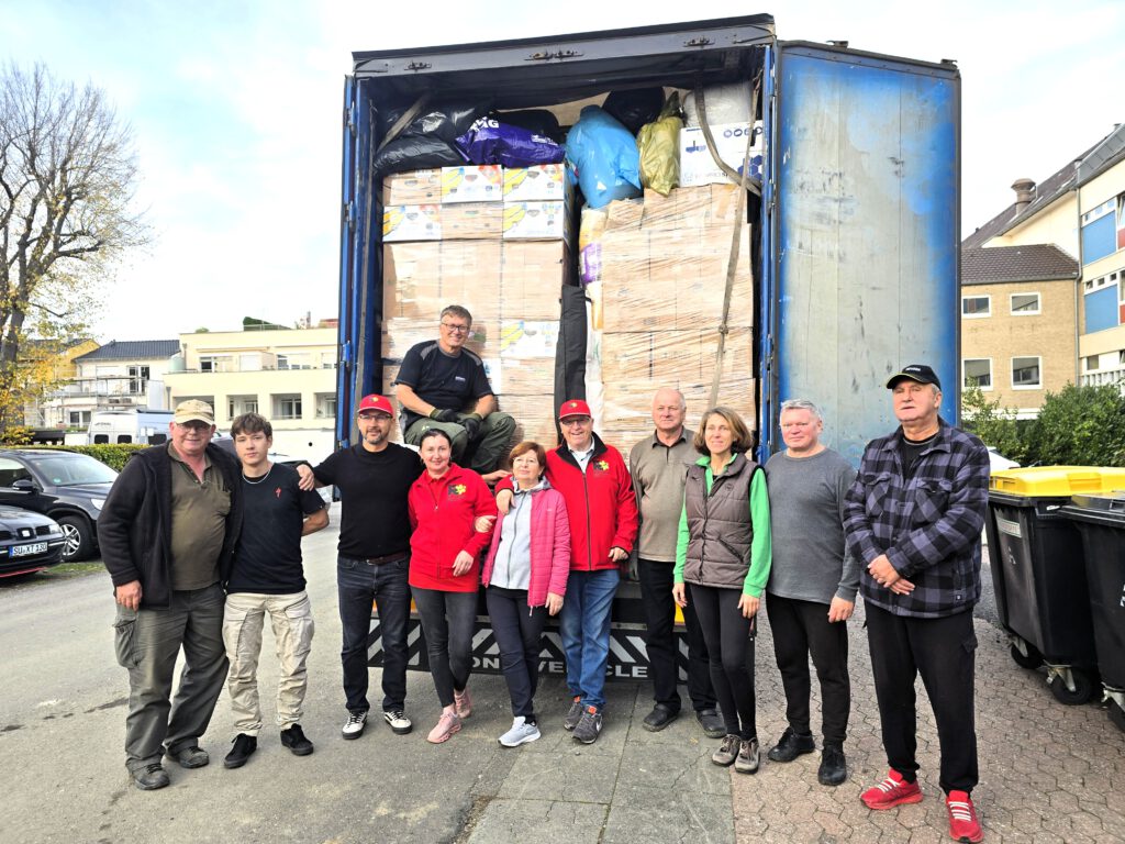 Das Bild zeigt unser Ladeteam, das gerade den 40to LKW im Hintergrunbd beladen hat